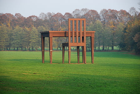 brown wooden desk and chair on green grass field thumbnail