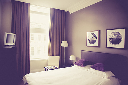 black wooden bed frame with beddings inside room thumbnail