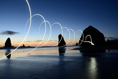 time-lapse photo of light streak near rock formations thumbnail