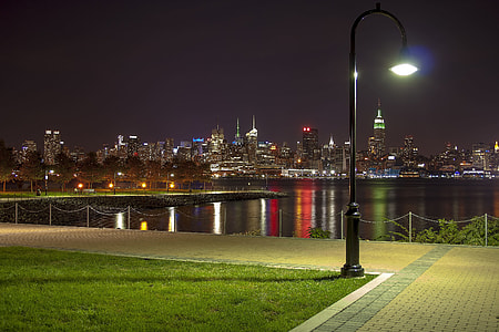 black lamppost with city building background during night thumbnail