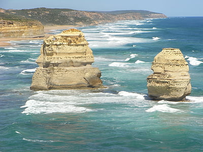 two beige rock formation on green body of water at daytime thumbnail
