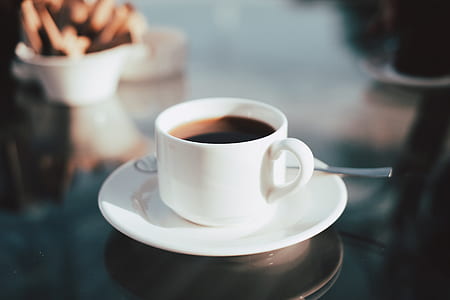 ceramic mug filled with coffee on white saucer thumbnail