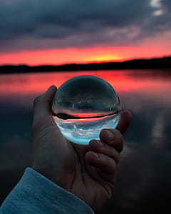 Person Holding Clear Glass Ball thumbnail