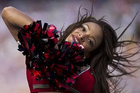 woman with pom-pom cheering during day thumbnail