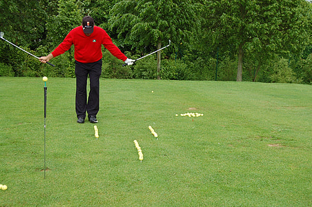 man holding two golf clubs thumbnail