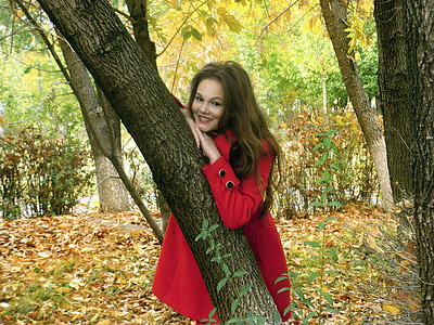 woman leaning on black tree trunk thumbnail