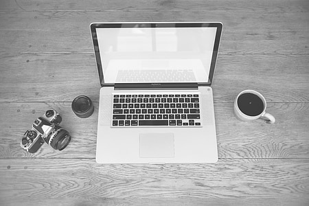 MacBook Pro beside mug teacup filled with black liquid substance and MILC camera thumbnail