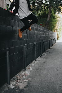 man jumping on black concrete fence thumbnail