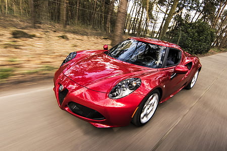 red sports car on road near trees during daytime thumbnail