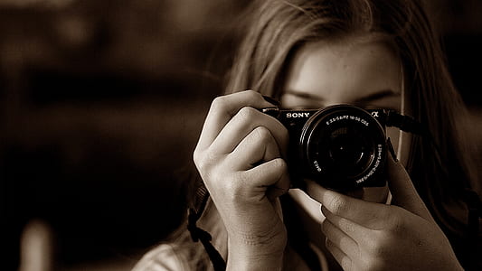 female holding camera thumbnail
