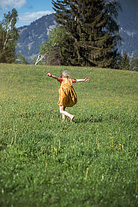 photo of girl running on green grass field near the pine tree thumbnail