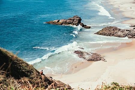 Blue ocean with tourists on a sandy beach thumbnail