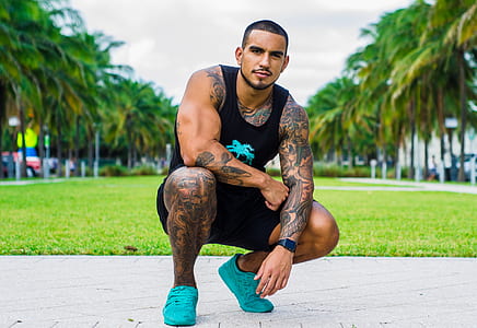 man in green grass field posing thumbnail