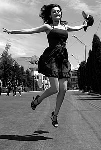 woman jumping while holding hat thumbnail