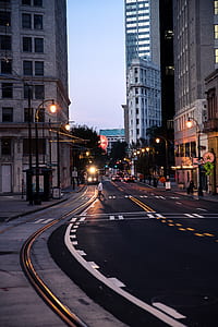 person crossing on highway between buildings thumbnail