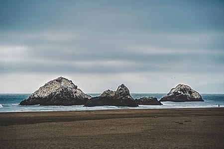 islands on water near seashore under gray sky thumbnail