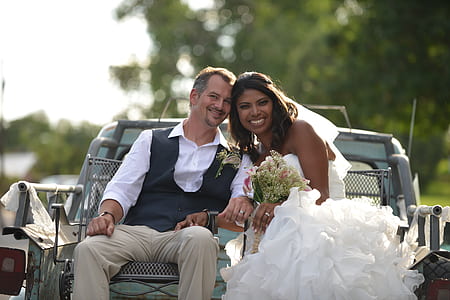 bride and groom riding the back of a truck during daytime thumbnail