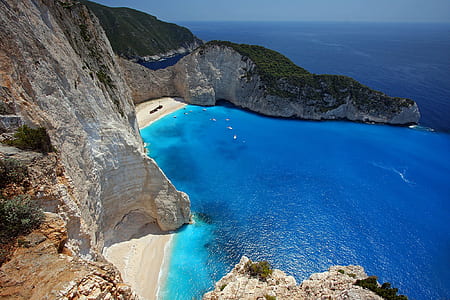 aerial photography of rocky mountain near clear blue ocean during daytime thumbnail