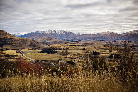 brown and green hills under cloudy sky thumbnail