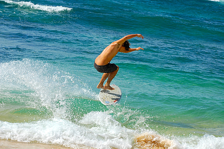 man playing skimboarding on blue body of water during daytime thumbnail