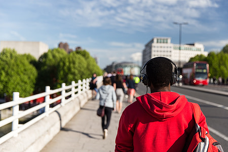 A man wearing headphones walks along a bridge over the River Thames on a sunny day in Central London. This image was captured using a Canon 6D DSLR thumbnail