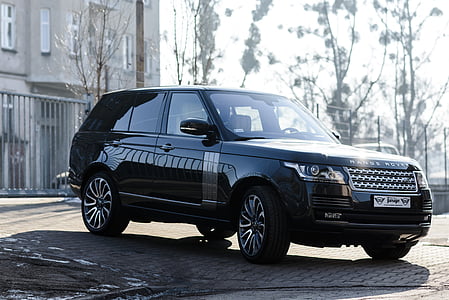 black Land Rover Range Rover SUV parked on pavement near fence and buildin thumbnail