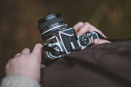 person holding black and gray DSLR camera thumbnail