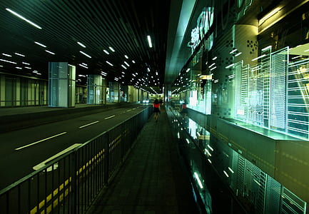 person in red shirt walking near black concrete road thumbnail