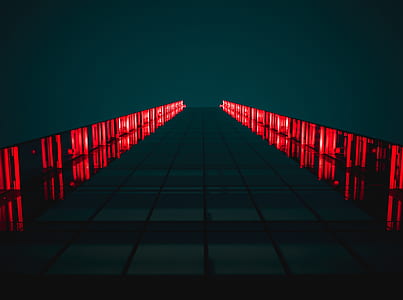 worm's eye view of glass building with red lights thumbnail