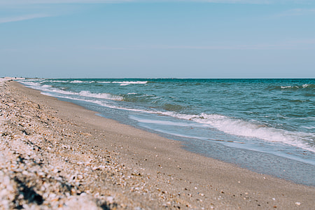 crashing waves at the seashore under blue sky at daytime thumbnail