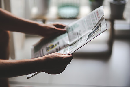 person holding newspaper thumbnail