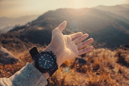 person showing round black analog watch thumbnail