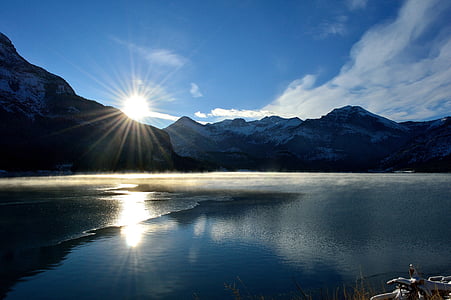 landscape photo of gray mountain near body of water during sunset thumbnail