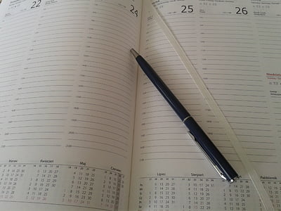 click pen placed on top of an open book planner thumbnail