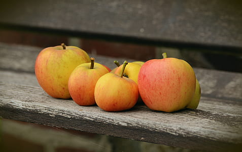 red-and-yellow apples on gray wooden surface thumbnail