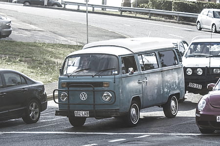 selective closeup photography of blue Volkswagen T1 van on road with other vehicles during daytime thumbnail