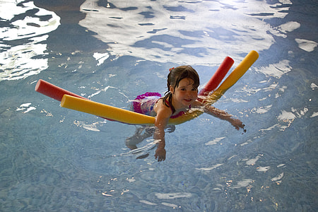 girl wearing white and pink shirt floating on body of water thumbnail