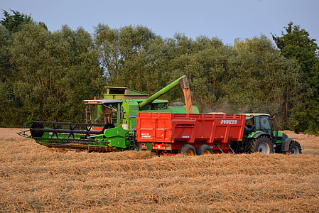 green rice harvester pouring rice on trailer truck thumbnail