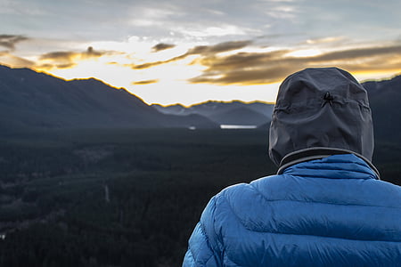 person wearing blue bubble jacket looking on sunset thumbnail