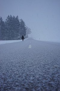 person walking on concrete road during winter thumbnail