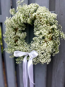 white flower wreath hanging on wooden surface thumbnail
