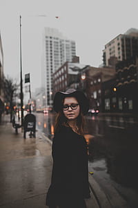 woman in black dress standing near buildings thumbnail