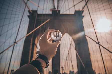 person holding lens front of Brooklyn Bridge thumbnail