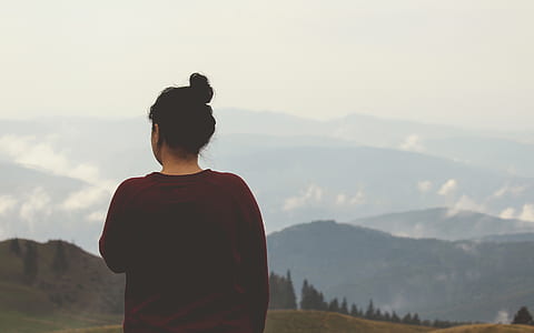 woman in red crew-neck shirt under gray sky during daytime thumbnail