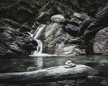 3-stone balance zen stone placed on gray rock in front of river stream at daytime thumbnail