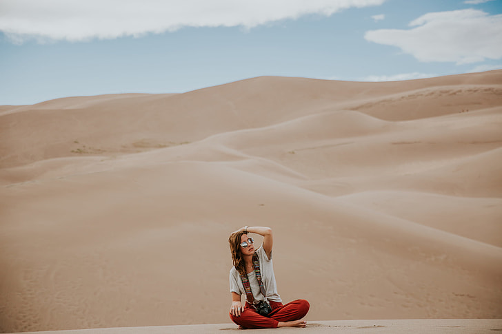 woman sitting on brown sand