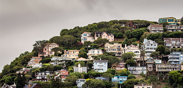 mountain with houses under gray sky thumbnail
