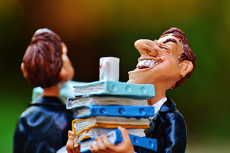 male cartoon character smiling while holding books figurine thumbnail