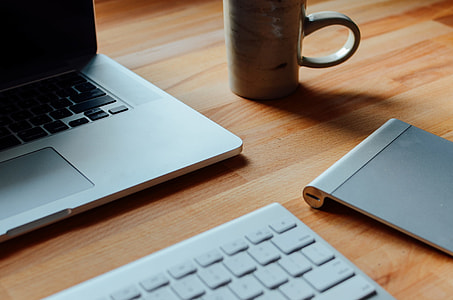 beige ceramic mug beside MacBook pro thumbnail