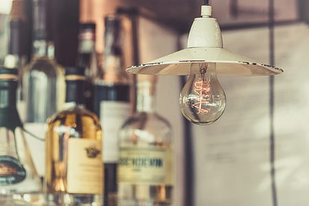 incandescent light bulb near wine bottles thumbnail